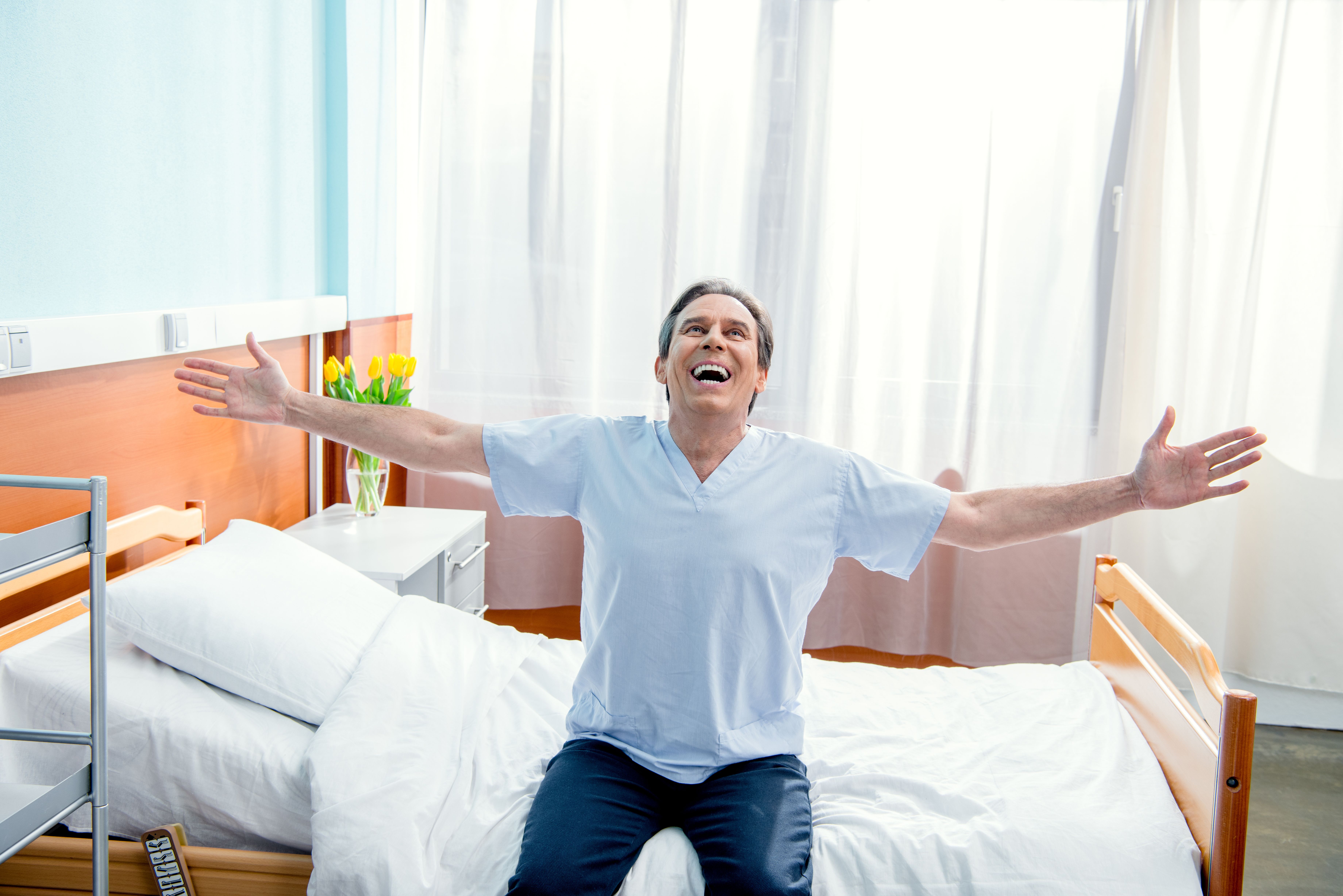 Man on hospital bed rejoicing an immediate recovery.