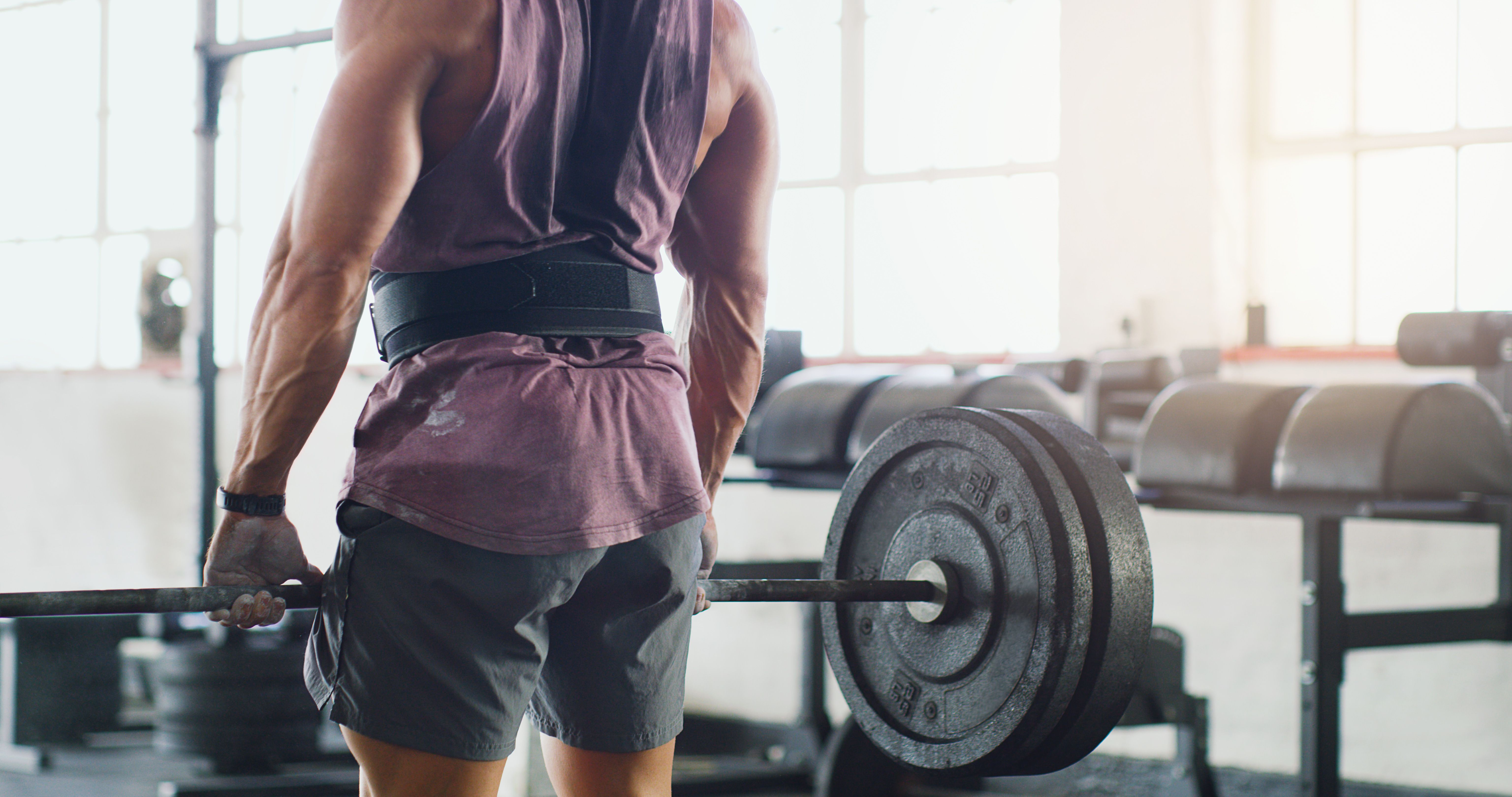 body builder lifting weights with brace